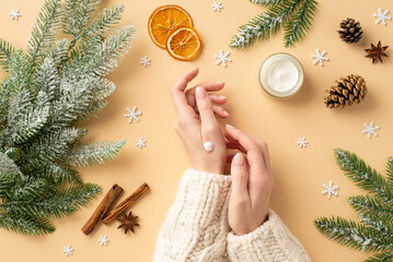 Winter skincare concept. First person top view photo of girl in pullover using hand cream jar...