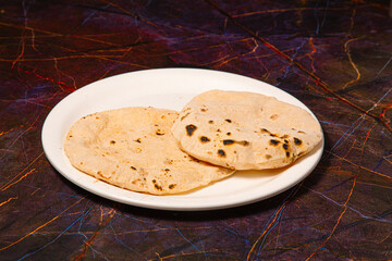Indian Traditional Cuisine Chapati or Roti, or Indian Bread in white plate with flour