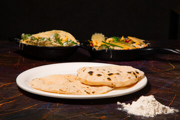Indian Traditional Cuisine Chapati or Roti, or Indian Bread in white plate with flour
