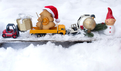 model of toy metal excavator, truck, warehouse loader, souvenir snowman standing on snow. festive...