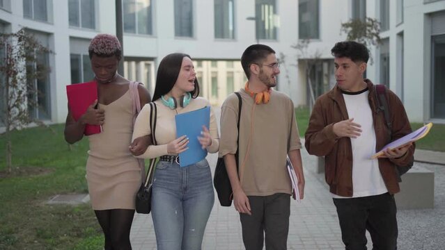 group of college students walk around the university campus talking about exams