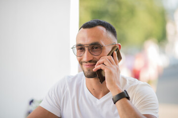 portrait of a young Spanish man talking on the phone, a man with a phone close-up