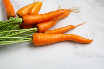 Close up of bunch of fresh carrots fresh vegetables on marble surface