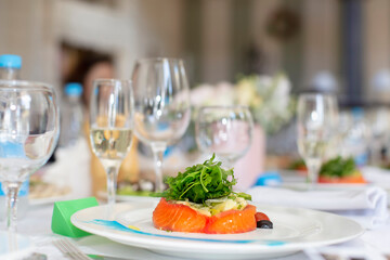 Close-up of a piece of red fish garnished with arugula on a plate in a restaurant.