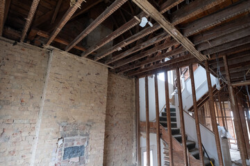 Building work underway in a suburban Edwardian house in Pinner, northwest London UK. The builder is taking the house back to brick, exposing the original bricks and wooden beams.