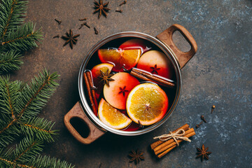 Hot Mulled wine cooking at home for happy christmas time. Red wine, orange, apple and spices -...