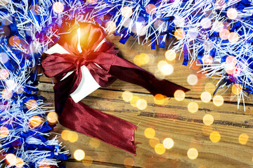 blue and white Tinsel around small gift box on wood table, merry Christmas concept