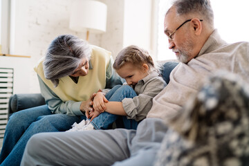 Senior couple sitting with little girl in living room