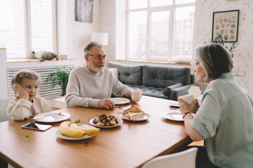 Grandparents and grandchild drinking hot beverages