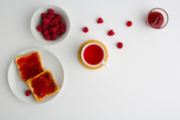 Cup of red tea and toasted bread with raspberry jam
