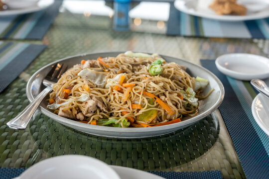 A large serving of Pancit Canton Guisado, a popular Filipino noodle dish.