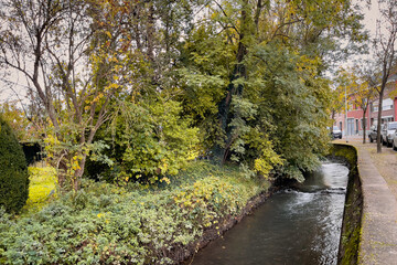 Cars parked on the roadside by Kleine Gete river in Zoutleeuw