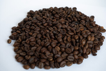 A handful of coffee beans on a white background. Roasted coffee beans.