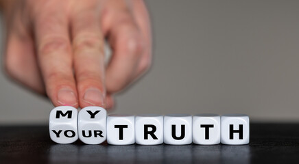 Hand turns dice and changes the expression 'your truth' to 'my truth'.
