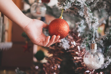 Close up look of Hand Holding red shiny ball with snoflake Christmas tree. Concept of Celebration Christmas background, postcard, presentation and banner Copyspace. Winter and Shiny. - Powered by Adobe
