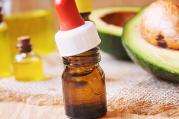 Avocado and avocado oil on wooden background. Selective focus.