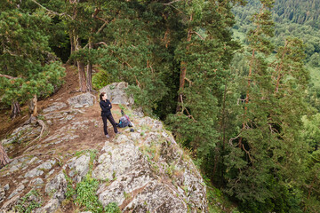 Aerial of female adventure hiker reaching top of wild viewpoint