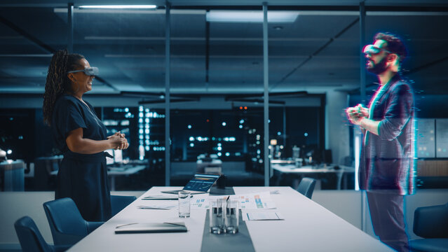 Future Office Online Meeting Video Conference Call: Businesswoman and Businessman Wearing Virtual Reality Glasses Talk using Augmented Reality Metaverse. Hologram Concept of Virtual Work Simulation. - Powered by Adobe