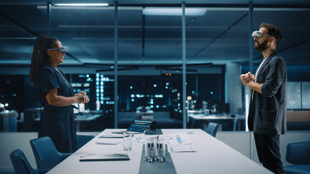 Office Online Meeting Video Conference Call: Businesswoman and Businessman Wearing Virtual Reality Glasses Talk using Augmented Reality Metaverse. Ultra Realistic Hologram of Employee Concept.