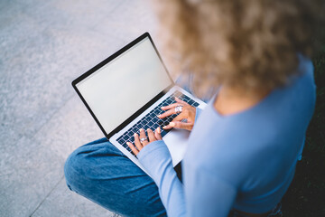Crop woman typing on laptop