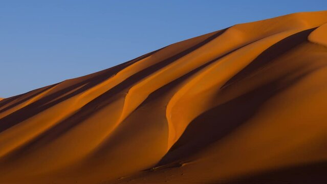 4k Time lapse at sunrise opening in the sand dune shadow, Rub Al Khali, Oman
