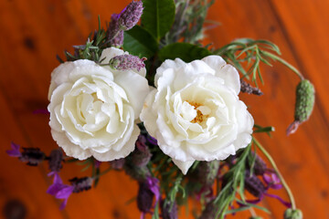 Natural flowers bouquet, white roses in a blur wooden background
