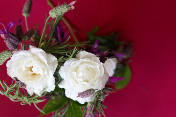 Natural white roses bouquet in dark red background