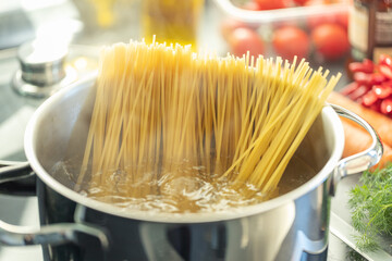 Girl cooking pasta spaghetti in pot