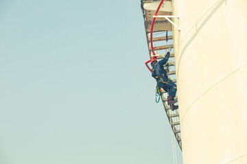 Male worker rope access inspection of thickness storage tank