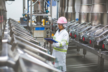 Male worker inspection the process of food drink at the manufacturing vertical factory stainless.
