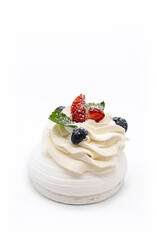 Meringue dessert Pavlova mini cake with fresh strawberries, blue