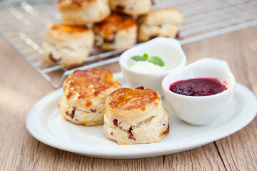 Cranberry scone set with raspberry jam and clotted cream - obrazy, fototapety, plakaty