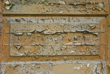  An old board with peeling brown paint. Close-up.