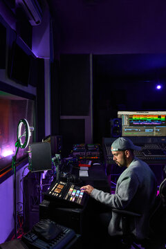 Professional audio engineer mixing sound during recording in studio