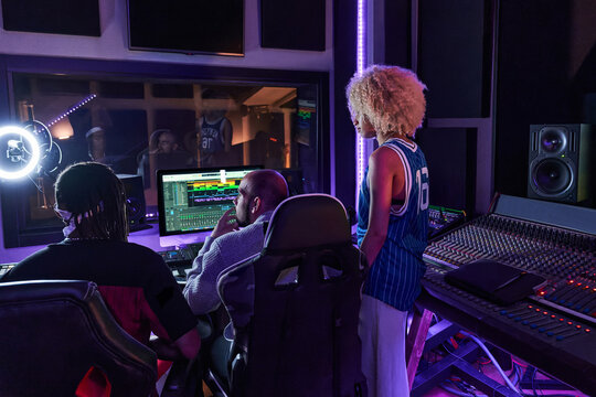 Group of multiethnic people working on music in recording studio