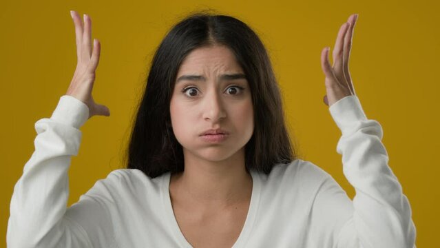 Female portrait in yellow studio background Indian ethnic woman lady girl showing mind blowing head gesture shocked information overwhelmed explosion sign problem trouble shock bomb stress reaction