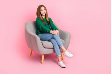 Obraz na płótnie Canvas Full length photo of sweet funny girl dressed knitted pullover sitting chair empty space isolated pink color background