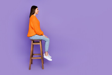 Full length photo of stunning young lady sit profile wooden stool dressed stylish orange knitted...