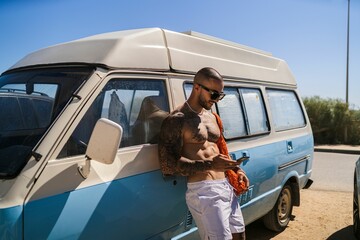 Attractive Caucasian male with tattoos near a van