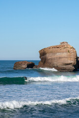 rocks in the sea with a surfer