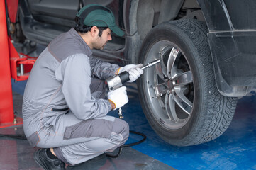 Obraz na płótnie Canvas Professional mechanic providing car repair and maintenance service in auto garage. Car service business concept.