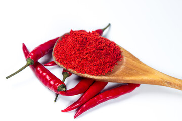 Red hot chili pepper and a spoonful of red ground pepper on a white background