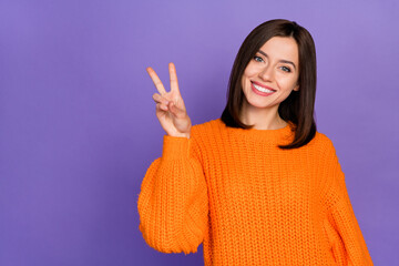Portrait of positive adorable girl beaming smile hand fingers demonstrate v-sign isolated on purple...