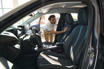 Potential car buyer assessing automotive upholstery quality