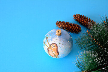 blue christmas sphere, spruce cones and branches with copy space