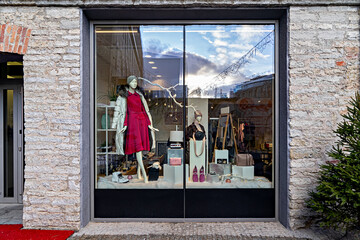 Exterior shop window display with female winter clothing and accessories, Christmas decoration. Xmas sale