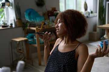 Small florist business owner recording a voice message on smartphone