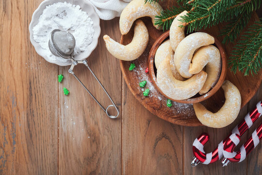 Christmas cookies crescents. Homemade traditional Christmas cookies Vanilla crescents in rustic plate with christmas decorations on old wooden rustic background. Food pattern. Holiday baking concept.