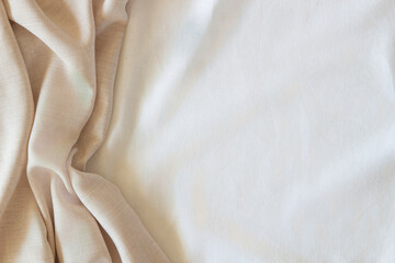 White and beige color crumpled linen fabric texture background. Natural off white wavy linen...