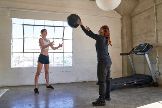 man and woman exercising throwing weighted ball